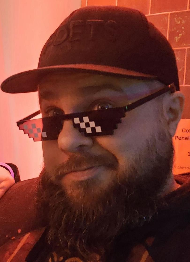 Portrait of Karol Cislowski wearing pixel sunglasses in a neon-toned setting.